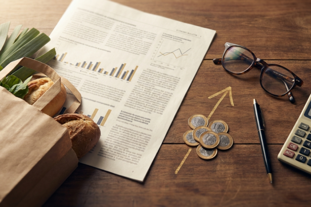 Sacola de compras ao lado de boletim economico e moedas com seta de alta representando o IPCA e a inflacao no Brasil